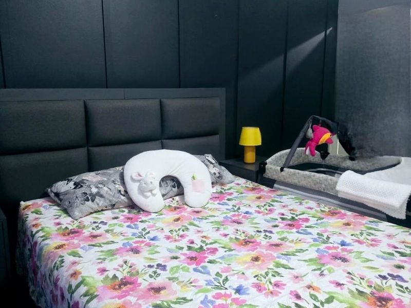 A bedroom featuring a dark feature wall with integrated paneling and a wall-mounted air conditioning unit.