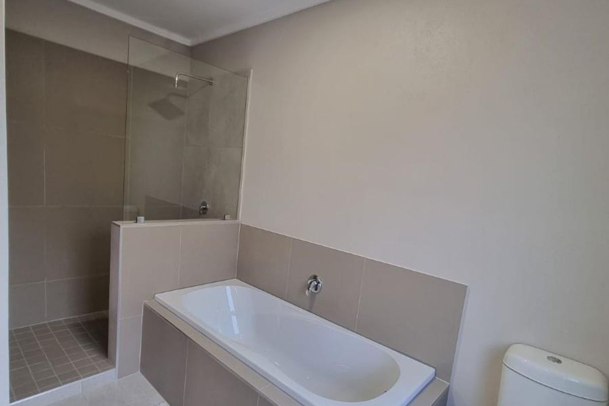 Modern bathroom featuring a built-in bathtub, a separate walk-in shower with a glass screen, and a standard toilet.