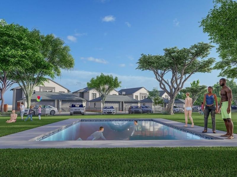 A communal swimming pool area set within a landscaped residential estate, featuring paved surrounds and views of modern housing units.