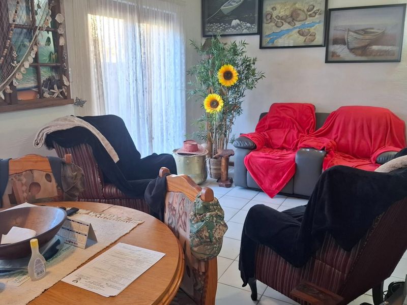 A living room area featuring tiled flooring and a sliding glass door providing natural light.