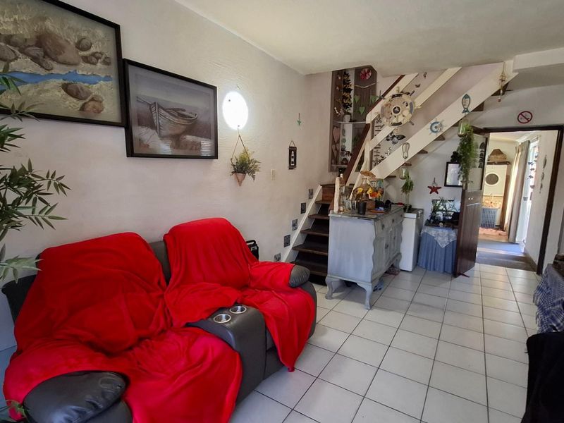 Living room area featuring tiled flooring and an internal staircase leading to the upper level.