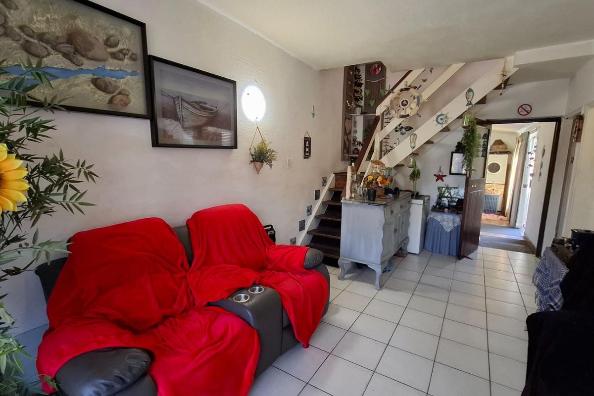 Living room area featuring tiled flooring and an internal staircase leading to the upper level.