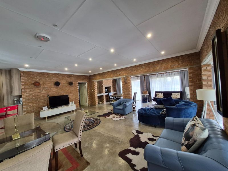 Spacious open-plan living area featuring exposed brick walls, polished concrete flooring, and recessed ceiling lighting, creating a warm and inviting atmosphere.