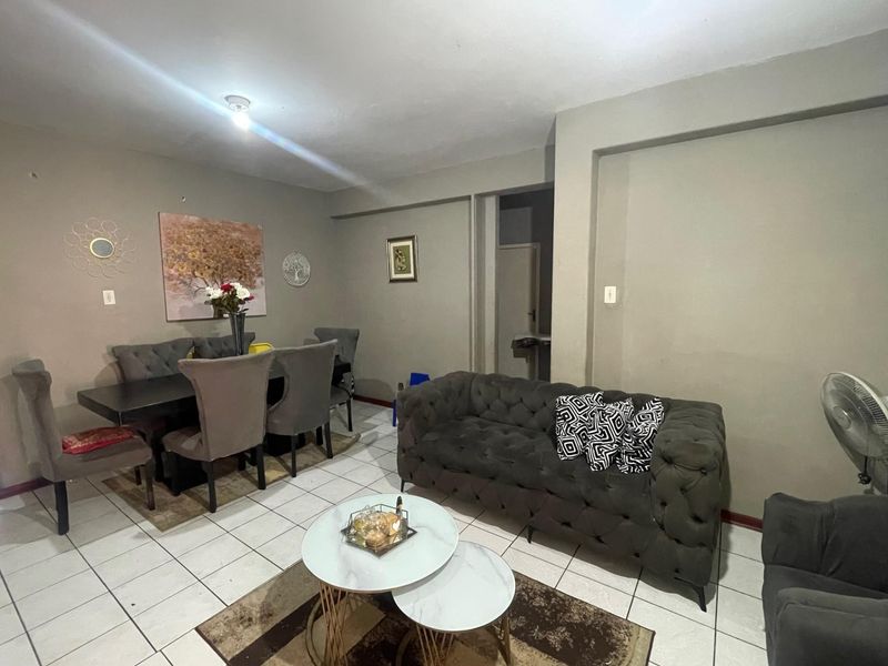 Open plan living and dining area featuring neutral wall tones and ceramic floor tiling throughout.