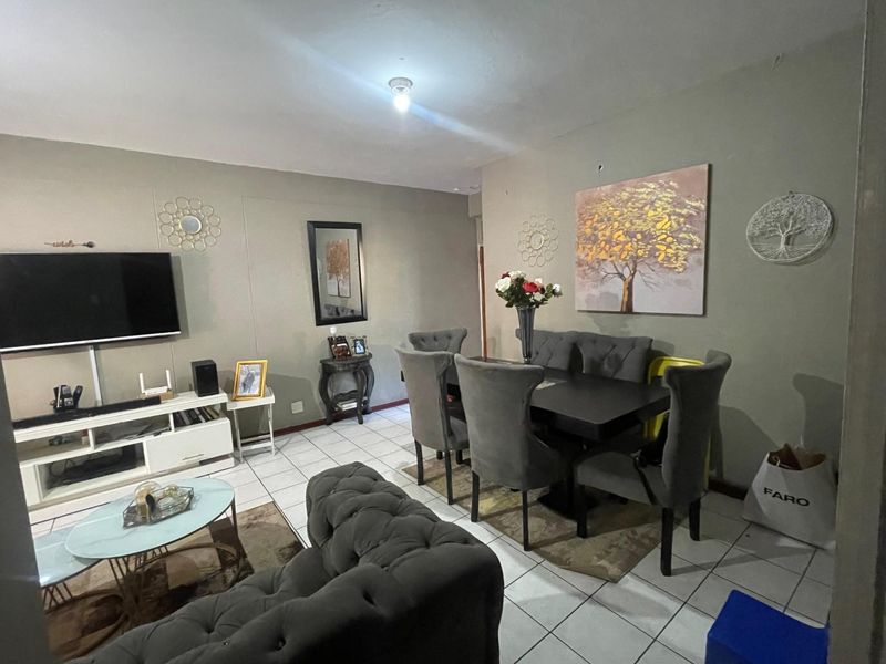 Open plan living and dining area featuring neutral wall tones and ceramic floor tiling throughout.