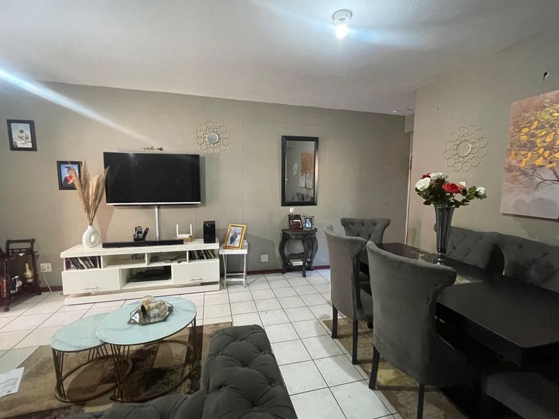 Open plan living and dining area featuring neutral wall tones and ceramic floor tiling throughout.