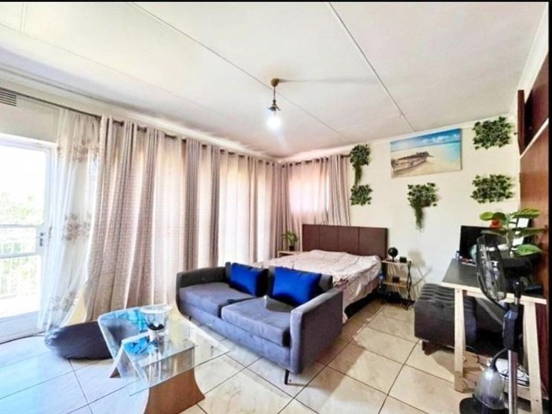 A bedroom featuring tiled flooring and a sliding glass door providing access to an outdoor area.