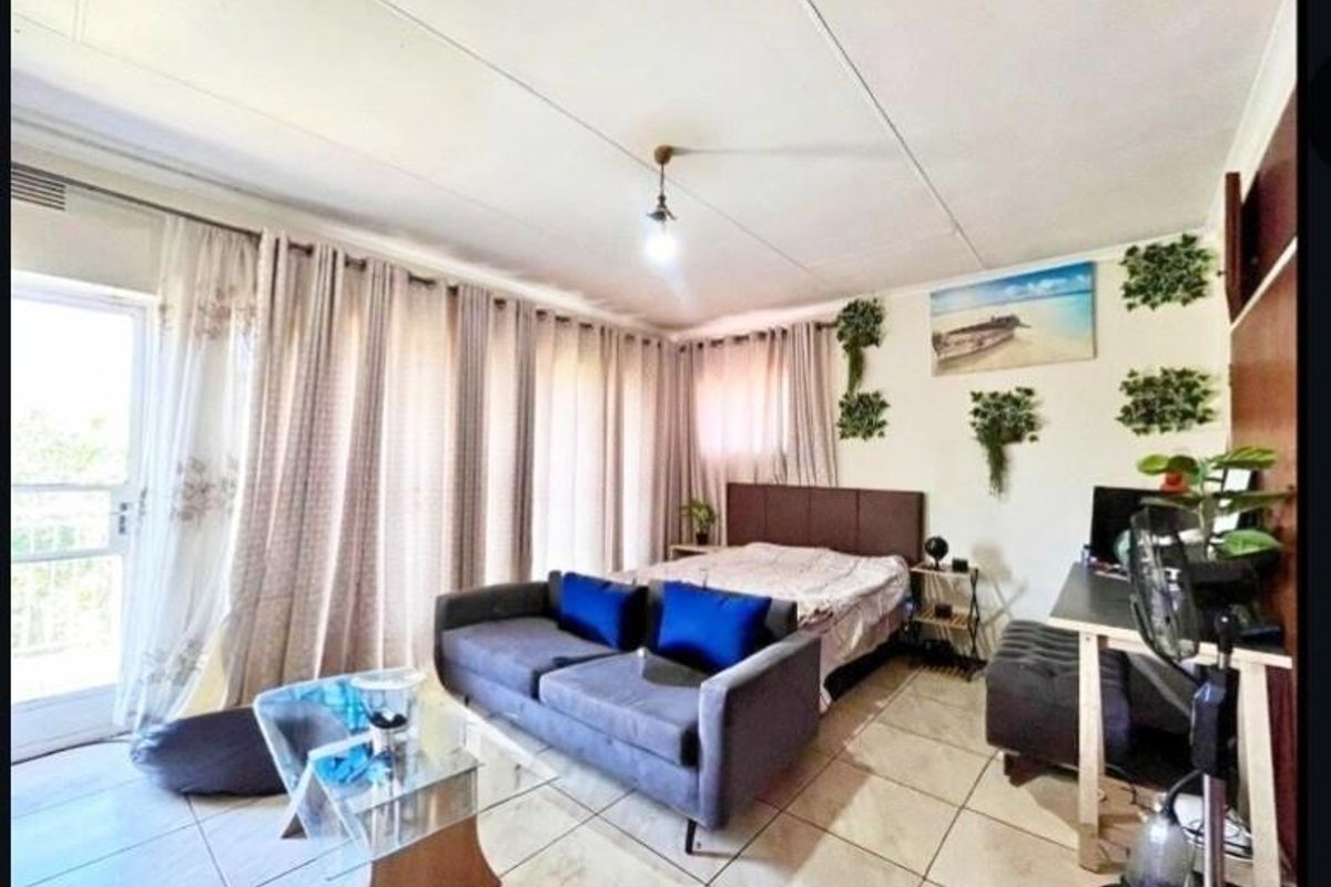 A bedroom featuring tiled flooring and a sliding glass door providing access to an outdoor area.