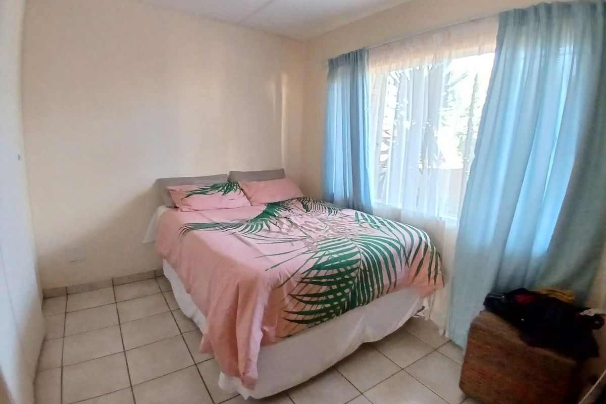 A functional bedroom featuring tiled flooring and a built-in cupboard, offering a simple and practical living space.