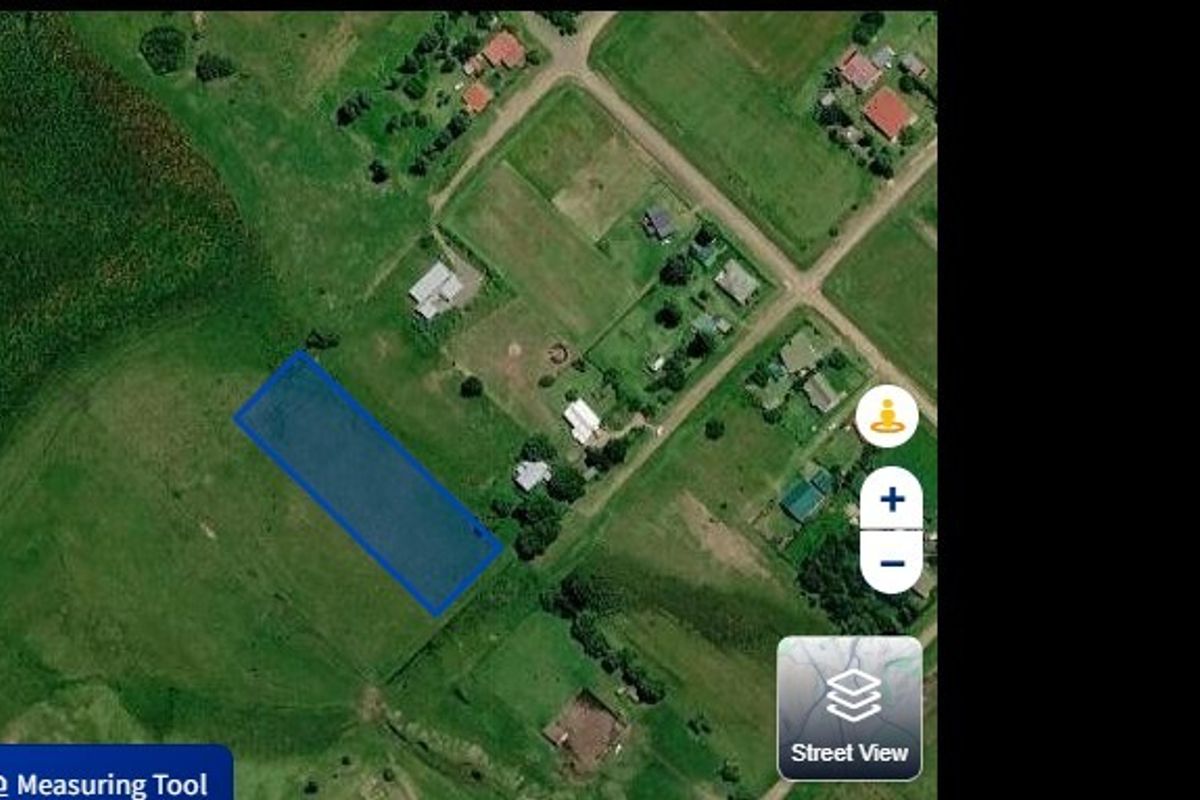 An aerial view showing the vacant residential land plot highlighted in blue within a rural neighborhood setting.