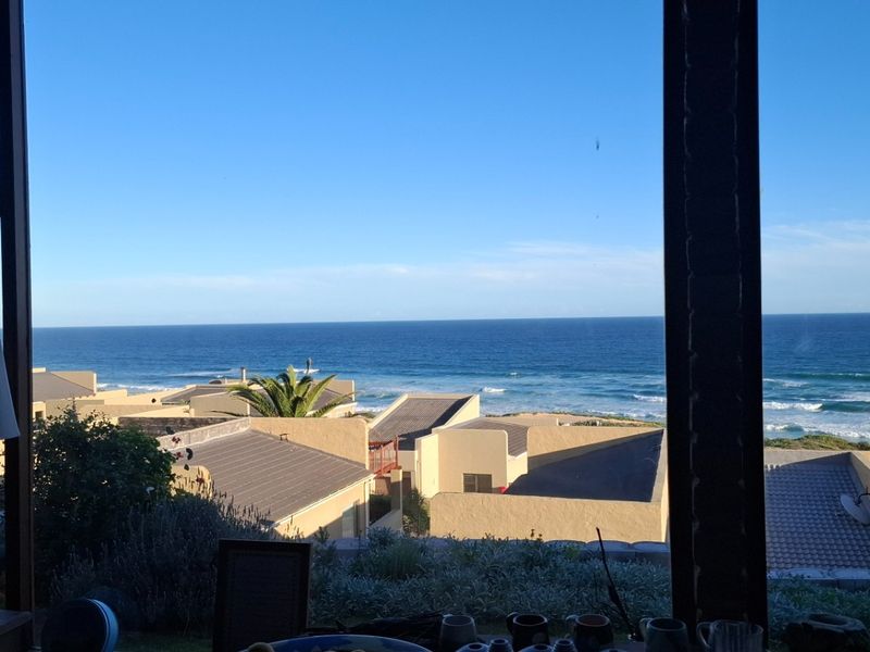 A scenic view of the ocean and surrounding coastal properties captured from an interior vantage point.