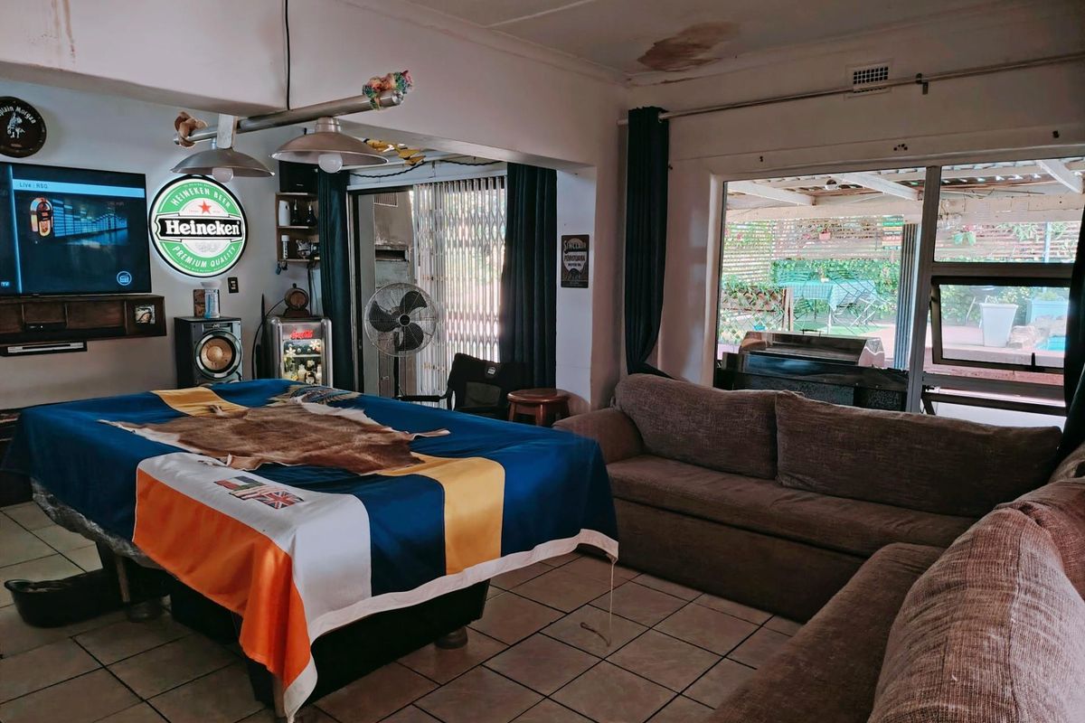 Spacious living area featuring tiled flooring and direct access to an outdoor patio through sliding glass doors.