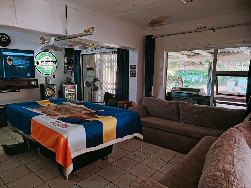 Spacious living area featuring tiled flooring and direct access to an outdoor patio through sliding glass doors.