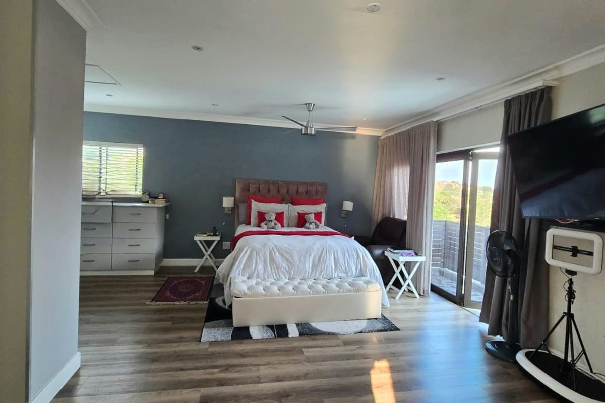 Spacious bedroom featuring wood-look flooring, recessed ceiling lighting, a ceiling fan, and sliding glass doors providing access to an outdoor area.