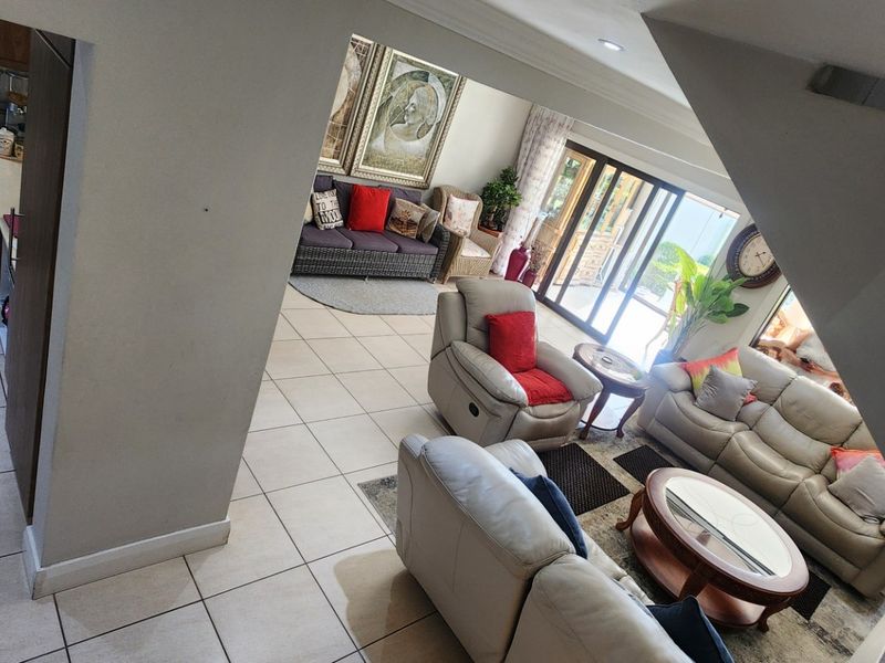 An open-plan living and kitchen area featuring tiled flooring, modern cabinetry, and large sliding glass doors that provide access to the outdoor space.