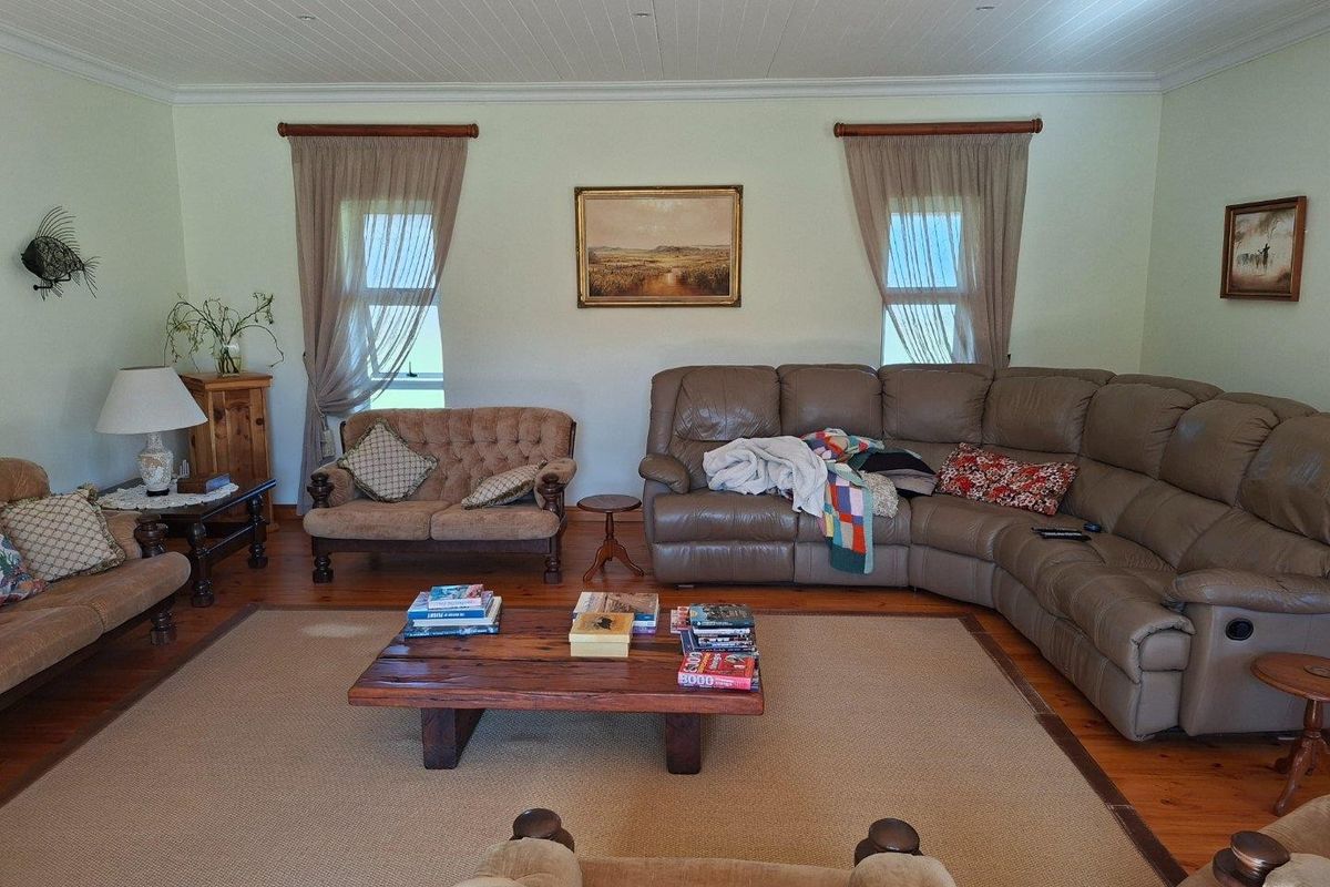 Spacious living room featuring warm timber flooring and a classic tongue-and-groove ceiling, offering a comfortable and inviting atmosphere.