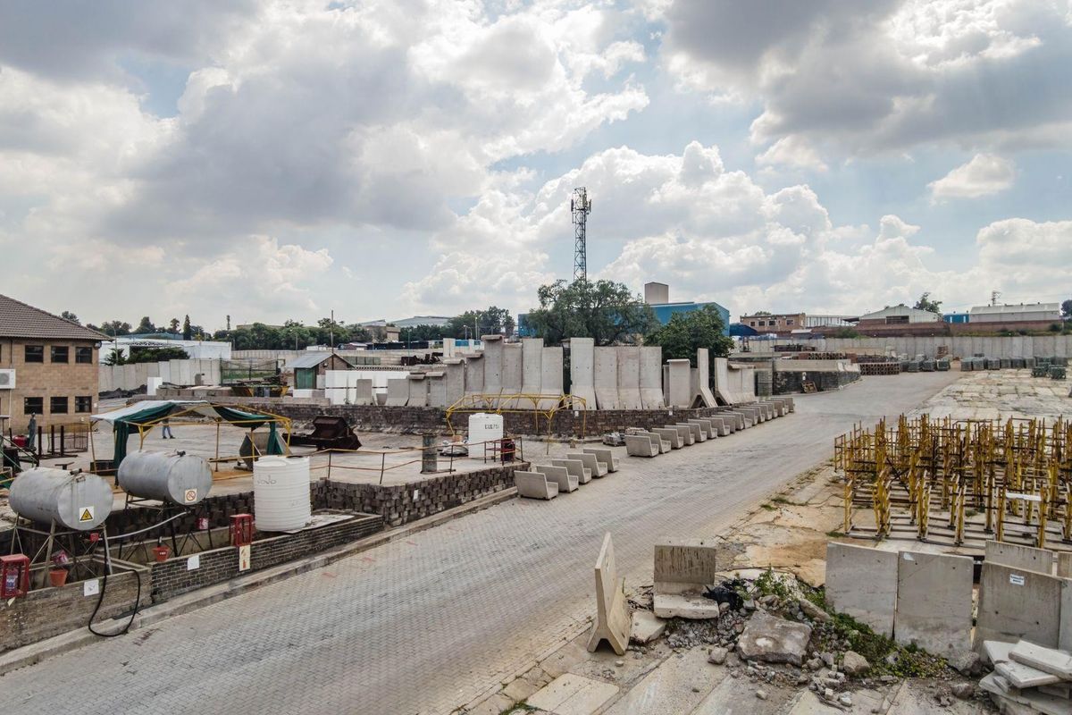 Expansive industrial yard featuring paved access, concrete retaining structures, and storage infrastructure, suitable for heavy-duty operations or logistics use.