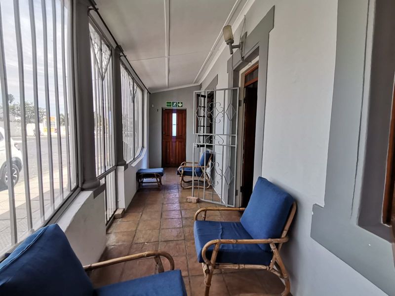 A covered patio or sunroom featuring tiled flooring, security bars, and direct access to the property interior.
