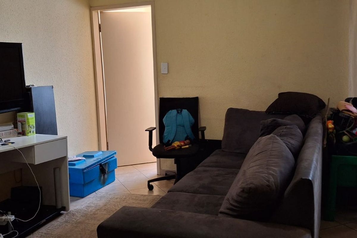 A living room area featuring tiled flooring and access to an adjacent room, providing a functional space for relaxation.