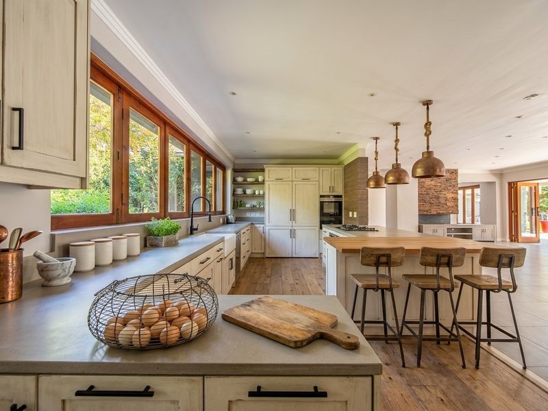 Spacious open-plan kitchen featuring custom cabinetry, stone countertops, a large central island with seating, and high-quality finishes throughout.