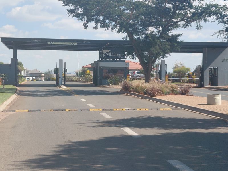 The main entrance gate to Wildtuinpark Estate, featuring a secure access control point with boom gates and signage.