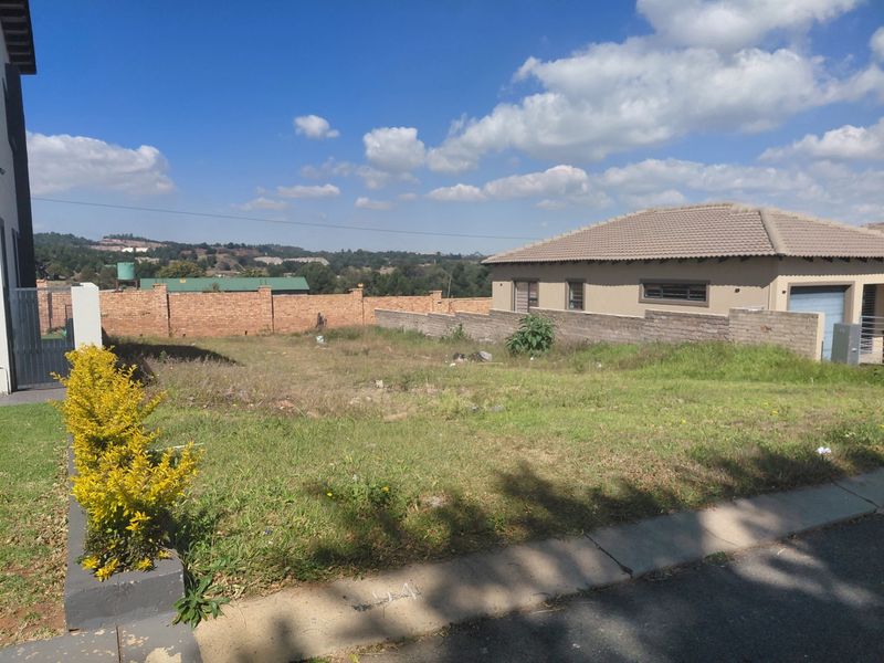 A vacant residential plot featuring established perimeter brick walling and surrounding neighborhood views, ready for development.