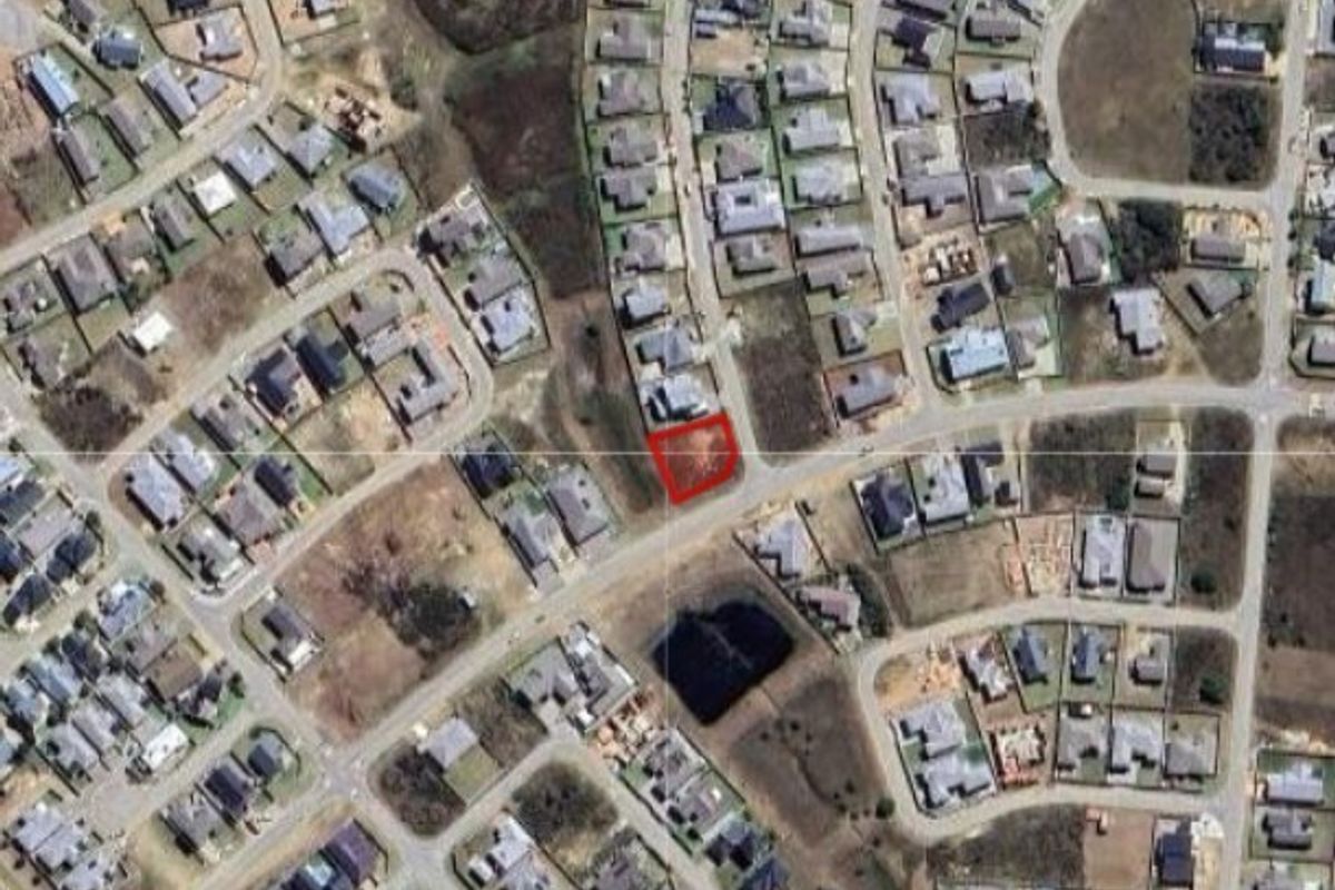 An aerial view of a vacant residential plot highlighted in red, situated within an established suburban neighborhood.