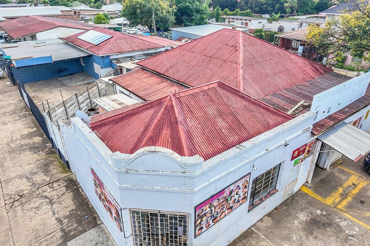 Aerial view of a commercial property featuring a corrugated metal roof, paved parking area, and street-facing signage.