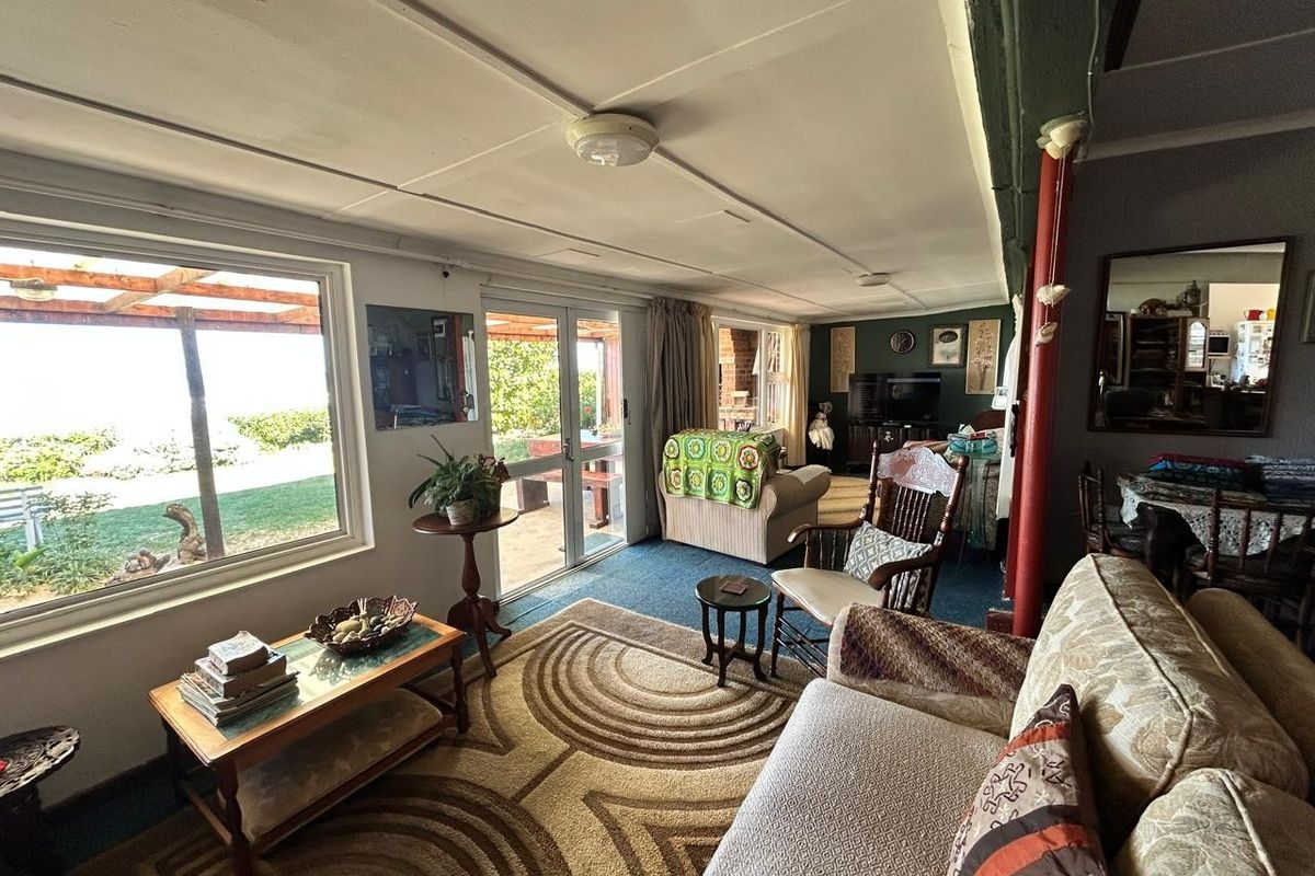 Spacious living area featuring large windows and sliding glass doors providing natural light and access to the outdoor patio area.