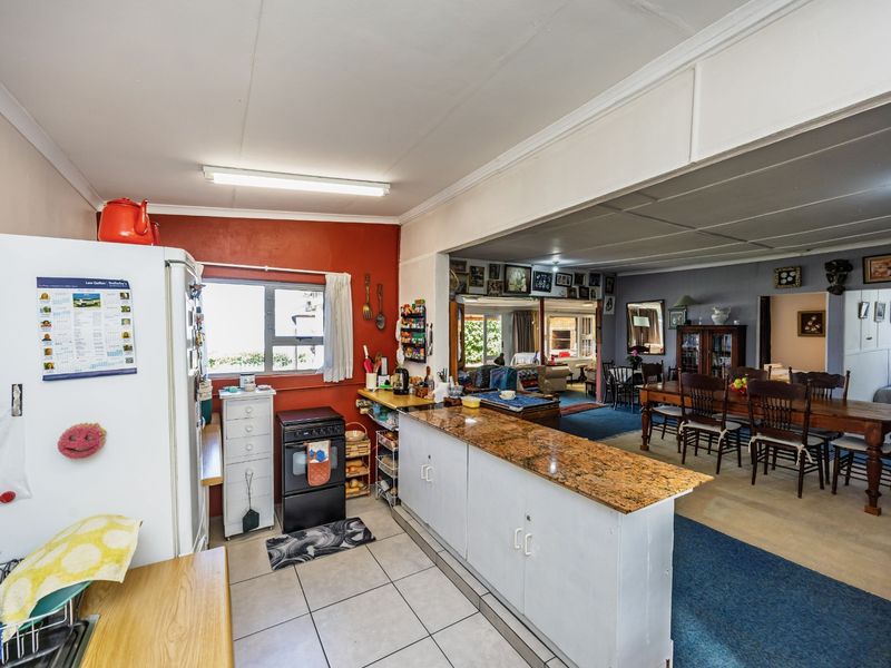 Open-plan kitchen and dining area featuring granite countertops, tiled flooring, and a functional layout connecting to the main living space.