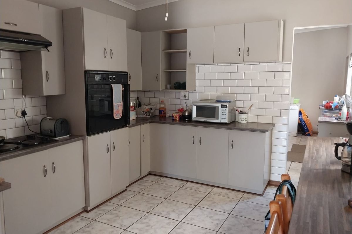 A functional kitchen featuring light-toned cabinetry, subway tile backsplash, built-in oven, and tiled flooring, offering a clean and practical workspace.