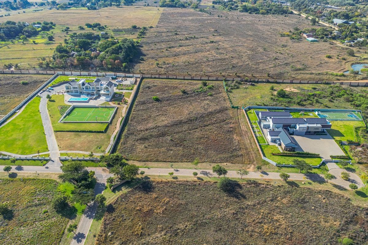 Aerial view of a vacant residential plot situated between two developed properties in a suburban estate.