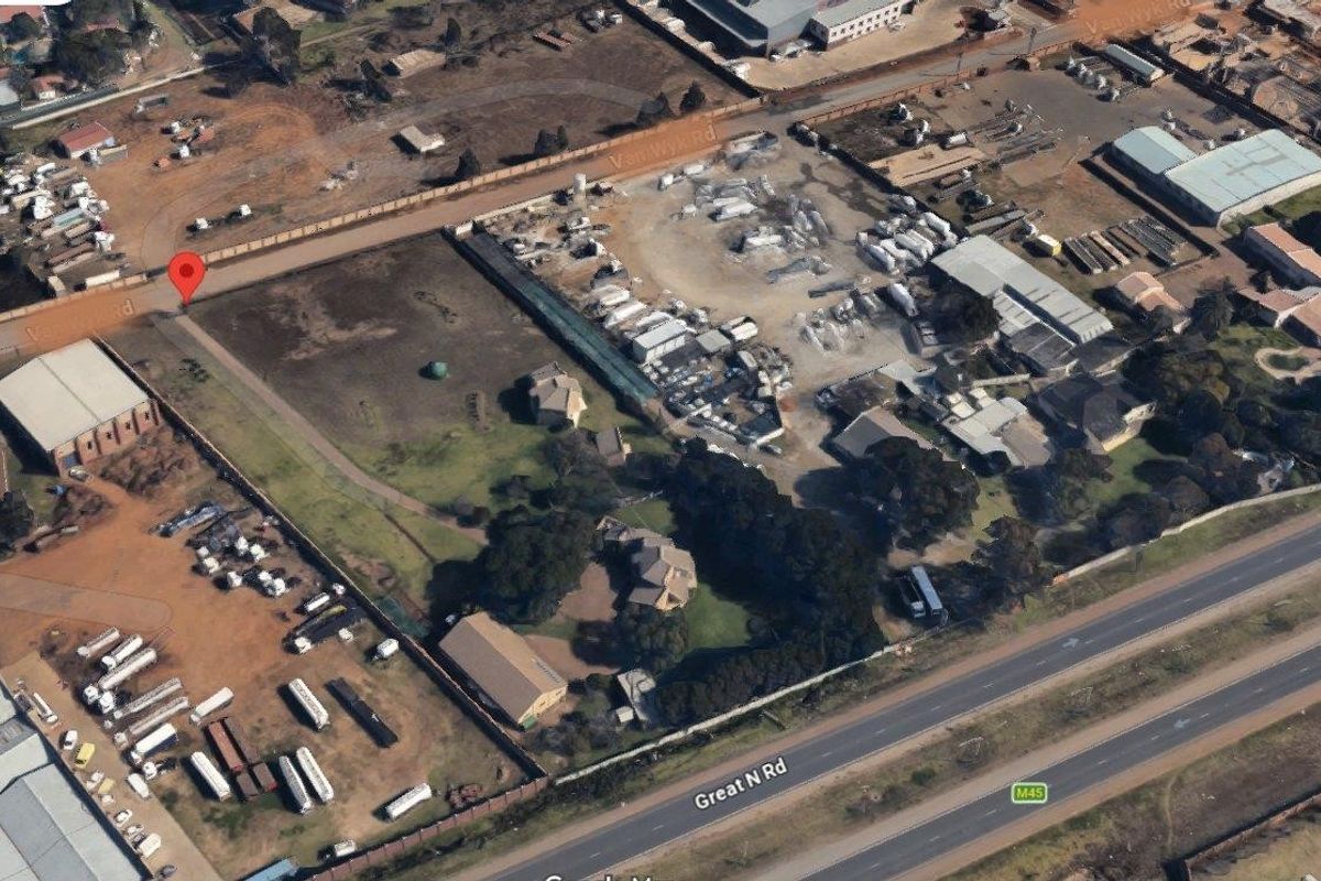 Aerial view of a commercial property site featuring multiple structures, open yard space, and direct access to the Great N Road.