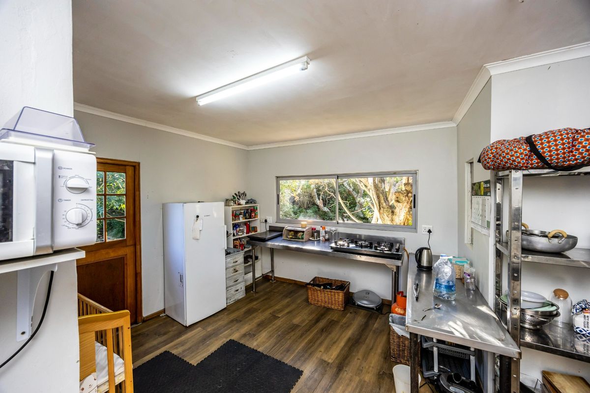 A functional kitchen area featuring stainless steel work surfaces, a built-in gas cooktop, and direct access to the exterior.