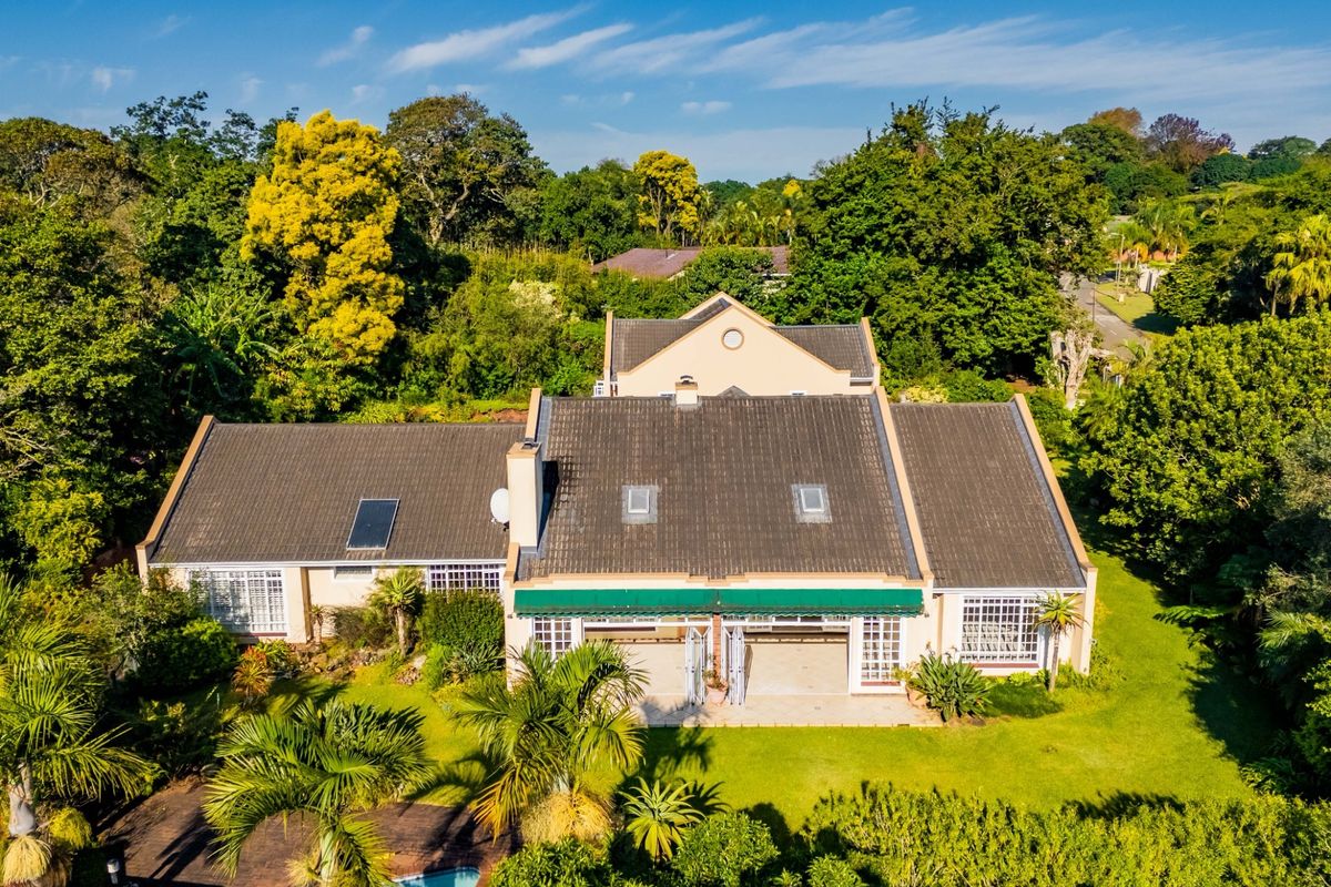 Aerial view of a townhouse featuring a tiled roof with solar panels, skylights, a rear patio with an awning, and a private swimming pool.