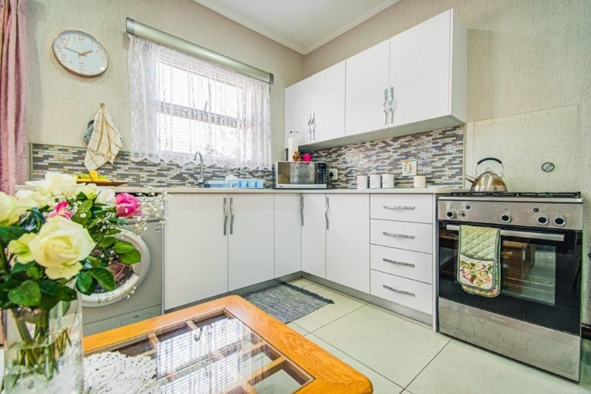 A functional kitchen featuring white cabinetry, a mosaic tile backsplash, tiled flooring, and a built-in oven with a gas hob.