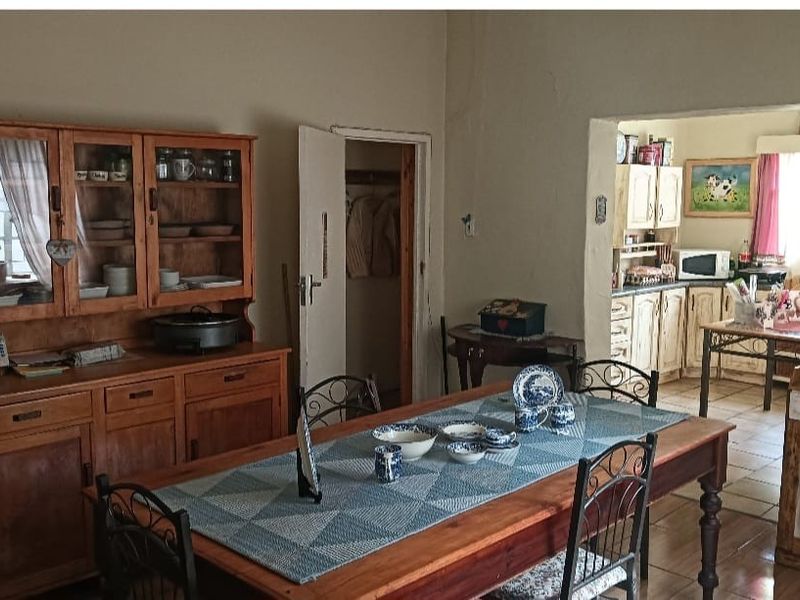 Open plan dining area featuring tiled flooring and a view into the adjacent kitchen space.