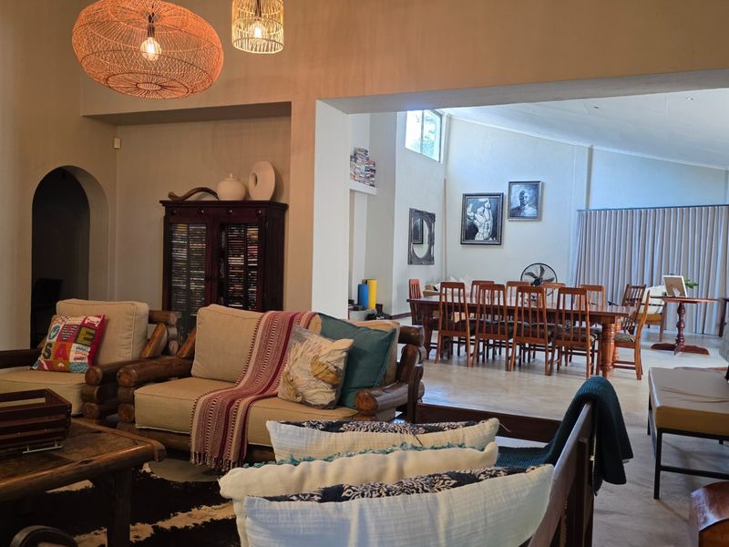 Spacious open-plan living and dining area featuring high ceilings, tiled flooring, and a seamless flow between the lounge and dining spaces.