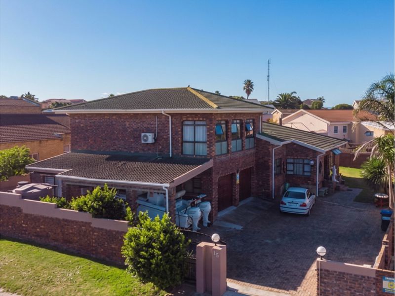 Aerial view of a double-story face-brick residential property featuring a paved driveway, integrated garage, and secure boundary walling.