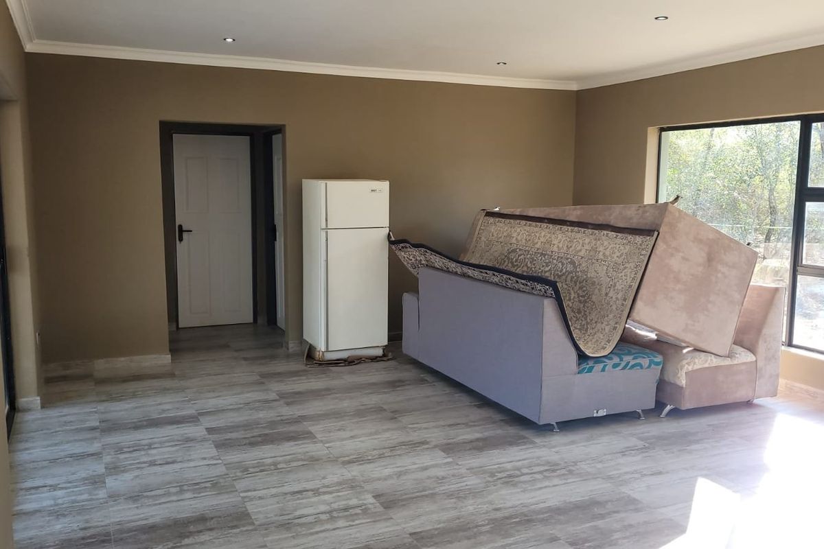 A spacious living area featuring large windows, tiled flooring, and recessed ceiling lighting, offering a neutral backdrop for potential interior design.