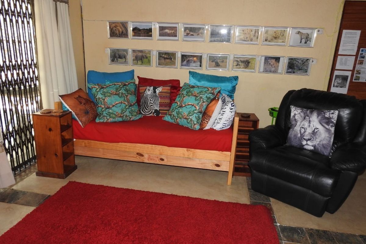 A living area featuring tiled flooring and a security gate, providing a functional space with neutral wall finishes.