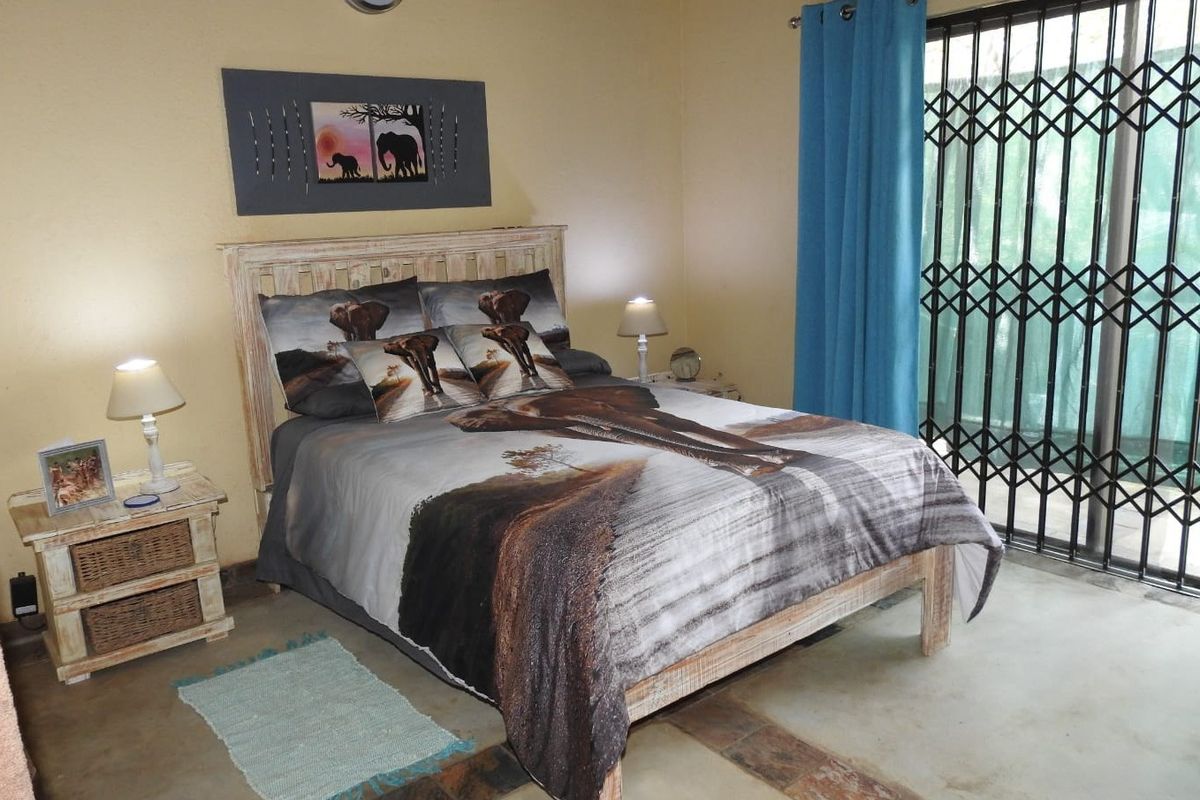 A bedroom featuring tiled flooring, a sliding door with a security gate, and access to an outdoor area.