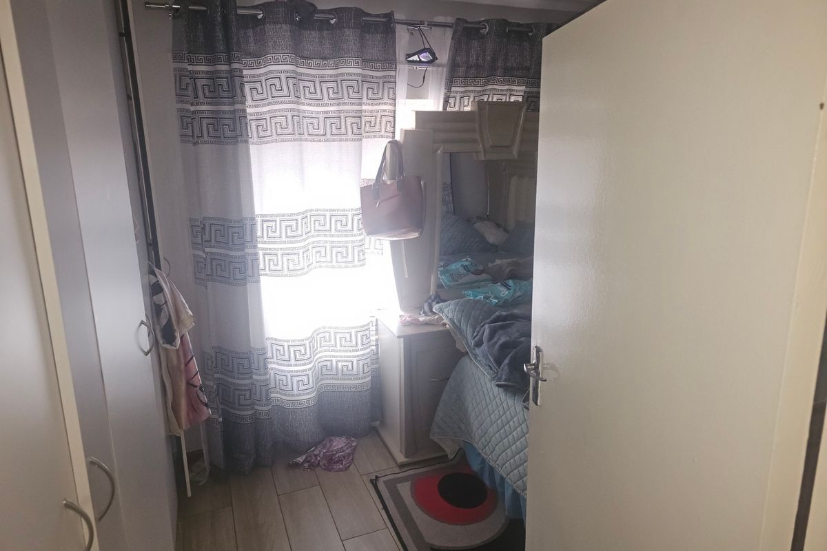 A bedroom featuring tiled flooring and built-in cabinetry, viewed from the doorway.