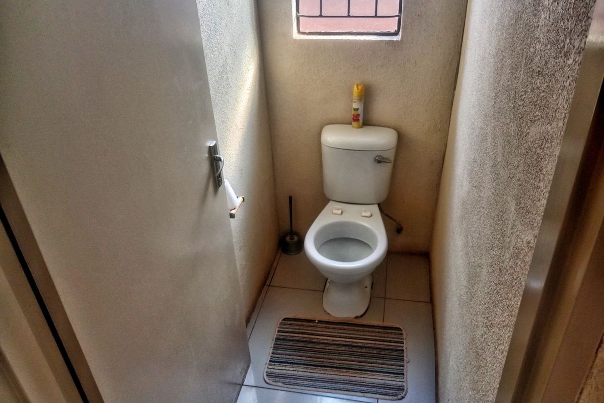 A compact, functional guest toilet featuring a standard white ceramic toilet suite and a small high-level window for ventilation.