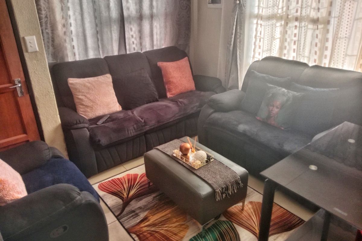 A cozy living room featuring tiled flooring and a functional layout, providing a comfortable space for relaxation.