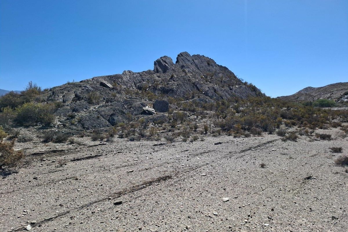 A scenic view of a natural rocky outcrop and arid landscape characteristic of the farm property.