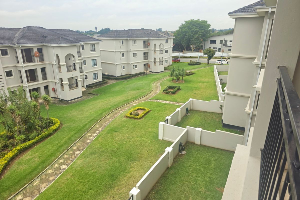 An elevated view overlooking the landscaped communal gardens and surrounding apartment blocks within the residential complex.