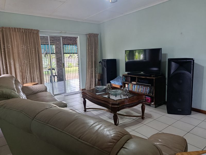 A living room featuring tiled flooring and a sliding glass door providing access to an outdoor patio area.