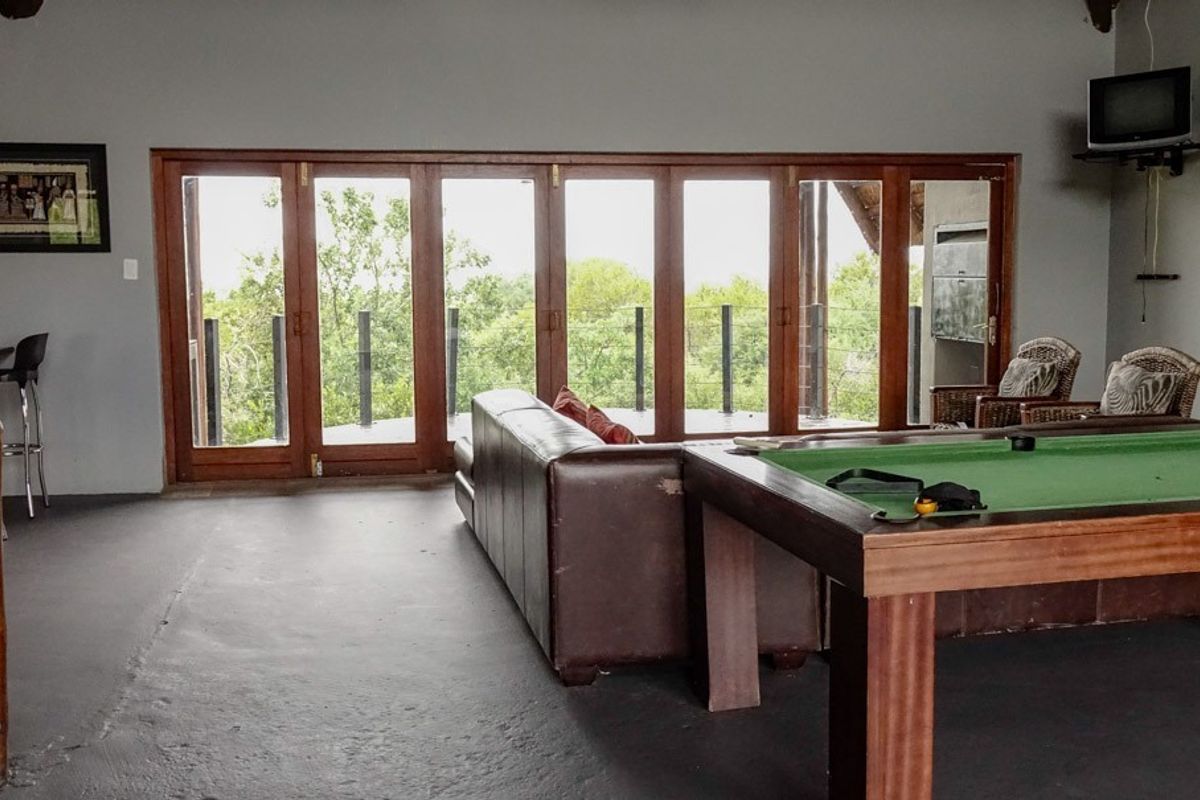 Spacious living area featuring large wooden folding doors that open onto a balcony, providing natural light and scenic views.