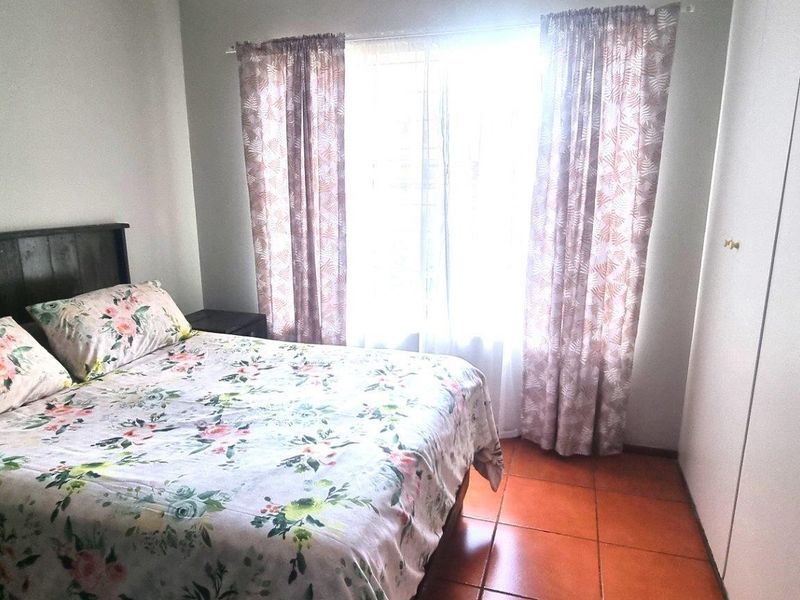 A bedroom featuring tiled flooring and built-in cupboards, providing functional storage space.